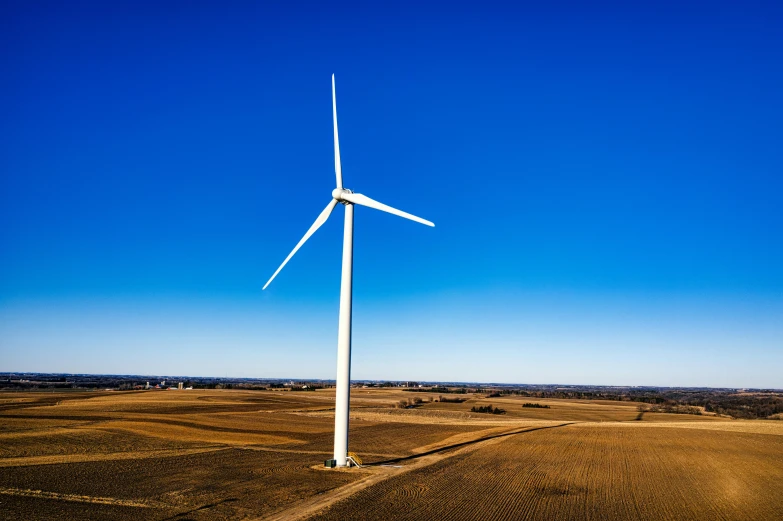 a wind turbine in the middle of a field, pexels contest winner, clear blue skies, midwest countryside, drone photograpghy, professionally post - processed