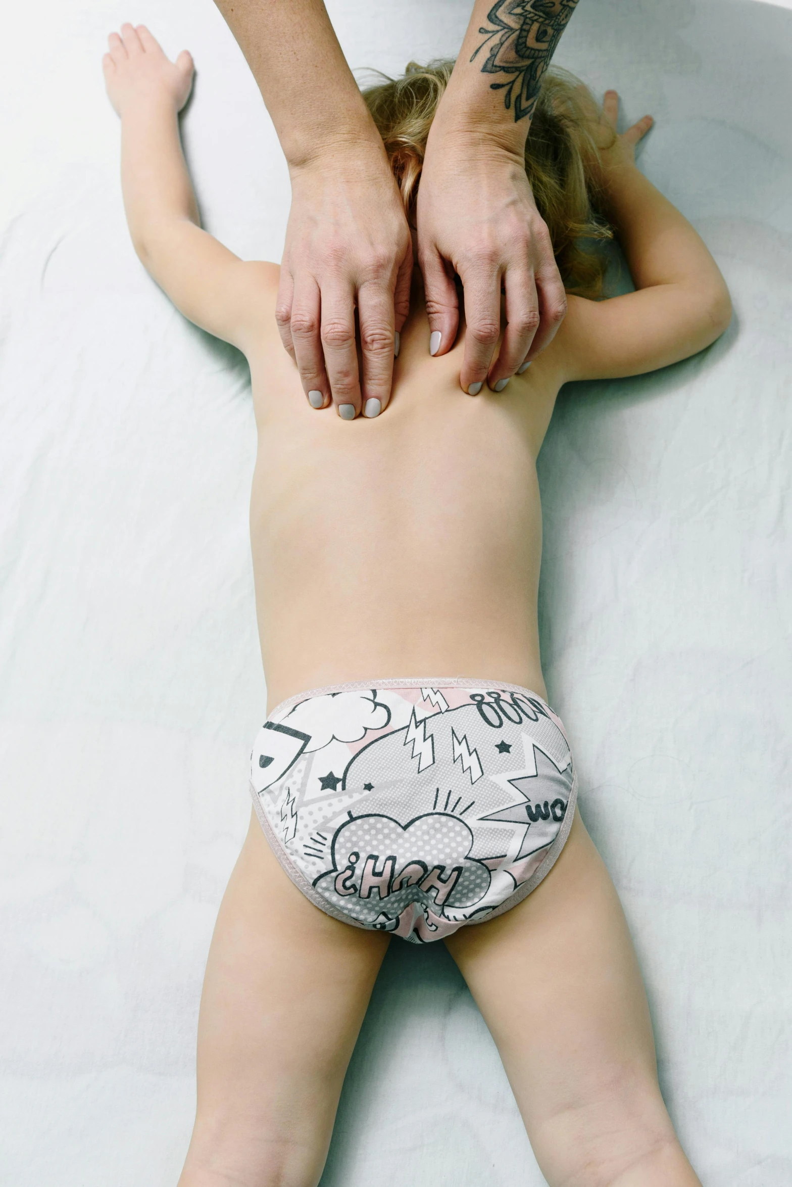 a baby laying on its back in a diaper, a child's drawing, by Lucia Peka, unsplash, happening, underwear ad, hand on hips, very very wide shot, graphic print