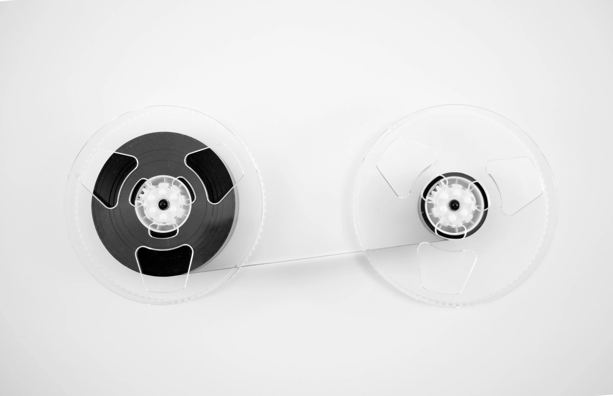 a couple of reels sitting next to each other, a black and white photo, by Jan Kupecký, unsplash, conceptual art, dieter rams, white plastic, animation, 8k archival print