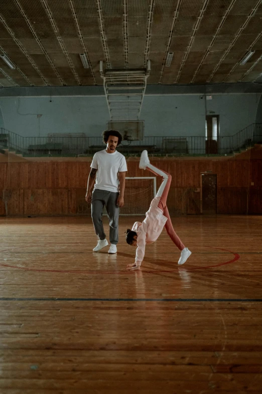 a couple of people standing on top of a wooden floor, arabesque, with afro, sports, taken with sony alpha 9, movie still