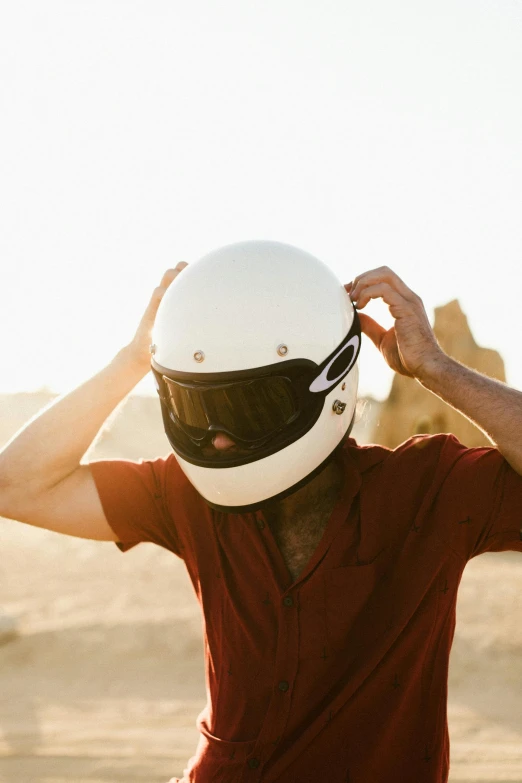 a man in a red shirt and a white helmet, trending on unsplash, deus ex machina, closed visor, in a desert, buckethead