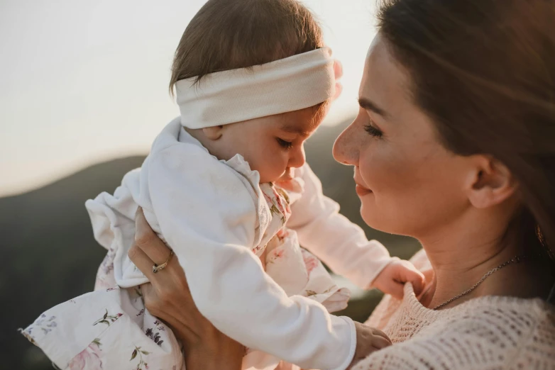 a woman holding a baby in her arms, pexels contest winner, manuka, avatar image, summer evening, profile image