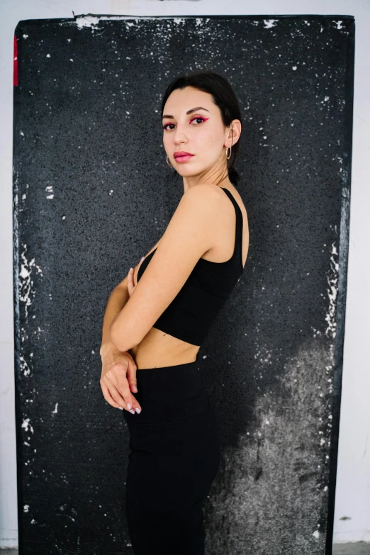 a woman in a black top and black pants, trending on pexels, portrait photo of a backdrop, wearing a crop top, raphael personnaz, woman with black hair