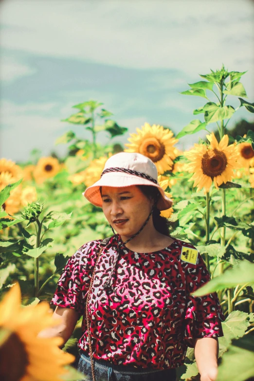 a woman standing in a field of sunflowers, inspired by Sun Kehong, wearing farm clothes, vibrant hues, chiho, brown