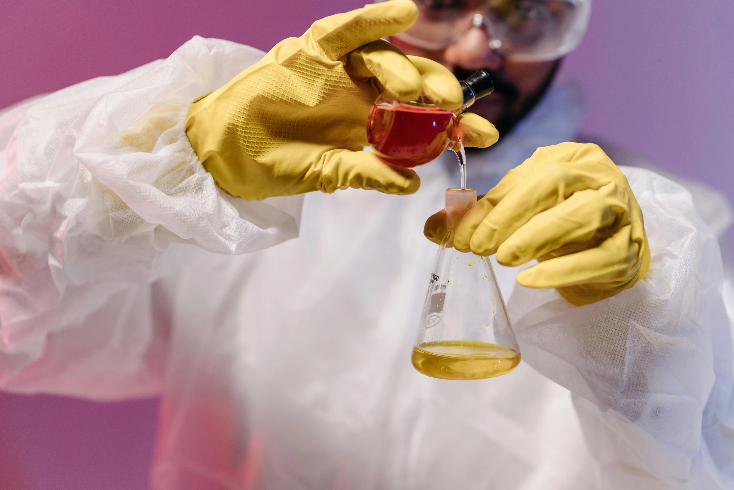 a man in a lab coat holding a glass filled with liquid, an album cover, pexels contest winner, synthetism, yellow latex gloves, yellow and purple color scheme, graphene, thumbnail