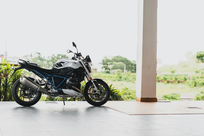 a black and blue motorcycle parked in a garage, unsplash, photorealism, sri lanka, avatar image, beautiful views