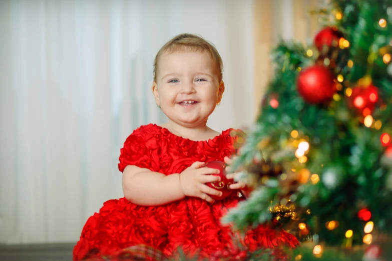 a little girl in a red dress next to a christmas tree, a portrait, by Julia Pishtar, shutterstock contest winner, 15081959 21121991 01012000 4k, smiling girl, 2 years old, youtube thumbnail