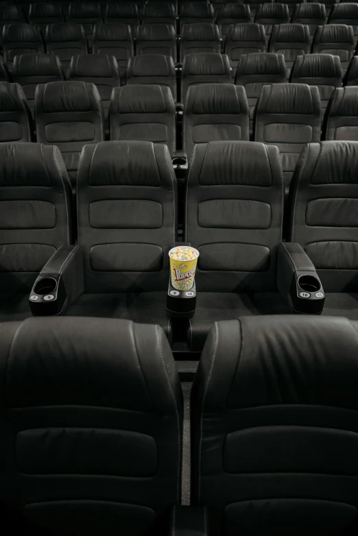 a cup of coffee sitting on top of a seat in a movie theater, imdb, blank, cinestill 400t, sony pictures