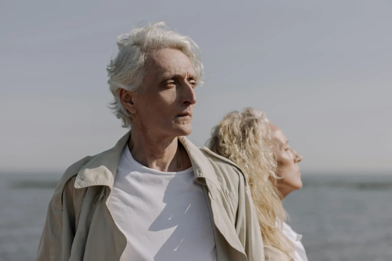 a man and a woman standing in front of a body of water, pexels contest winner, photorealism, white haired, looking upwards, cinematic footage, ad image