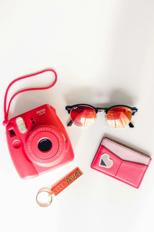 a pink camera sitting on top of a table next to a wallet, trending on pexels, red sunglasses, orange hue, profile pic, flat lay