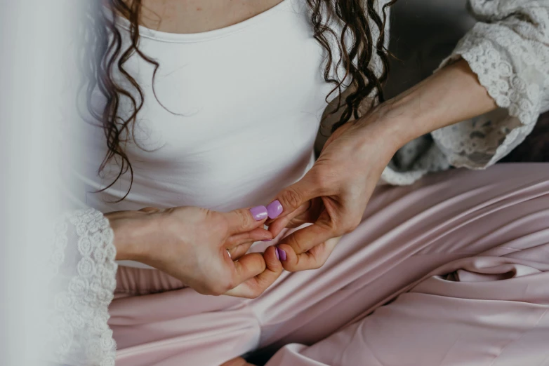 a woman in a white shirt and pink pants, trending on pexels, unclipped fingernails, connection rituals, manuka, seated in royal ease