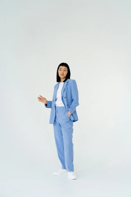 a woman in a blue suit posing for a picture, trending on pexels, on a pale background, ryan jia, work clothes, 1 5 0 0