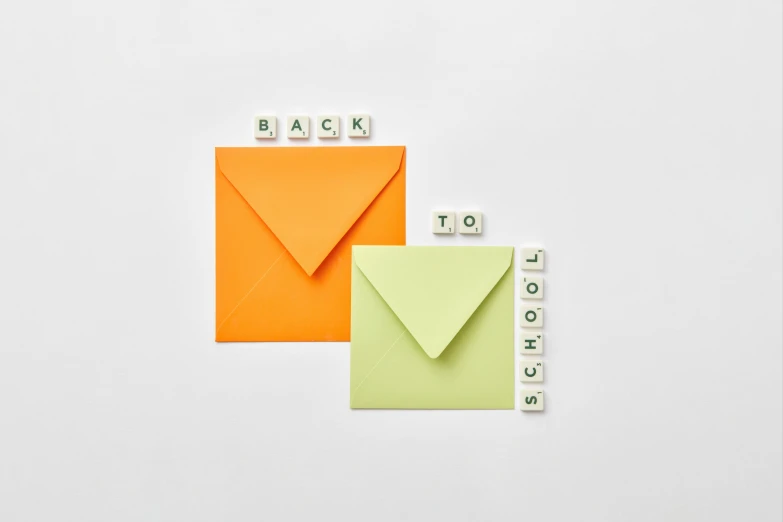 a couple of envelopes sitting on top of each other, unsplash, letterism, square shapes, green and orange theme, teacher, back to back