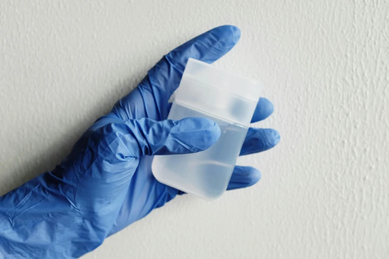 a person in a blue glove holding a plastic container, soft opalescent membranes, silicone cover, holding an epée, thumbnail