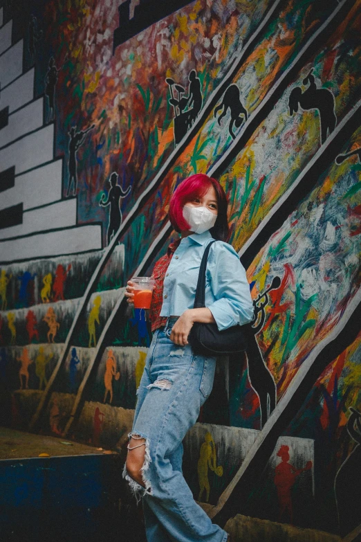 a woman wearing a face mask standing in front of a graffiti wall, a picture, by Jang Seung-eop, trending on pexels, red dyed hair, with a drink, colorful]”, instagram picture