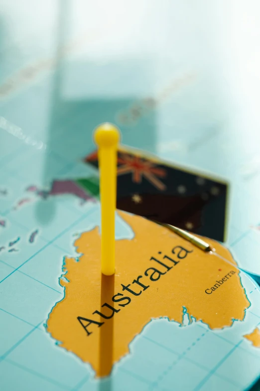 a close up of a map with a pin in it, by Nicolette Macnamara, shutterstock contest winner, happening, aussie, yellow, gloss, mini model