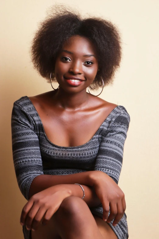 a woman sitting on a stool with her legs crossed, by Lily Delissa Joseph, shutterstock contest winner, natural hair, handsome girl, brown:-2, halfbody headshot