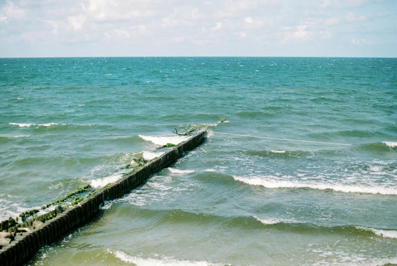 a broken pier in the middle of the ocean, an album cover, unsplash, romanticism, green sea, dunkirk, ignant, zig zag