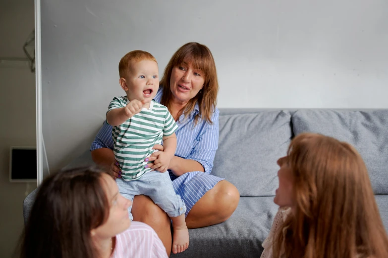 a woman sitting on a couch holding a baby, pexels contest winner, shouting, with tiny people, profile image, little boy