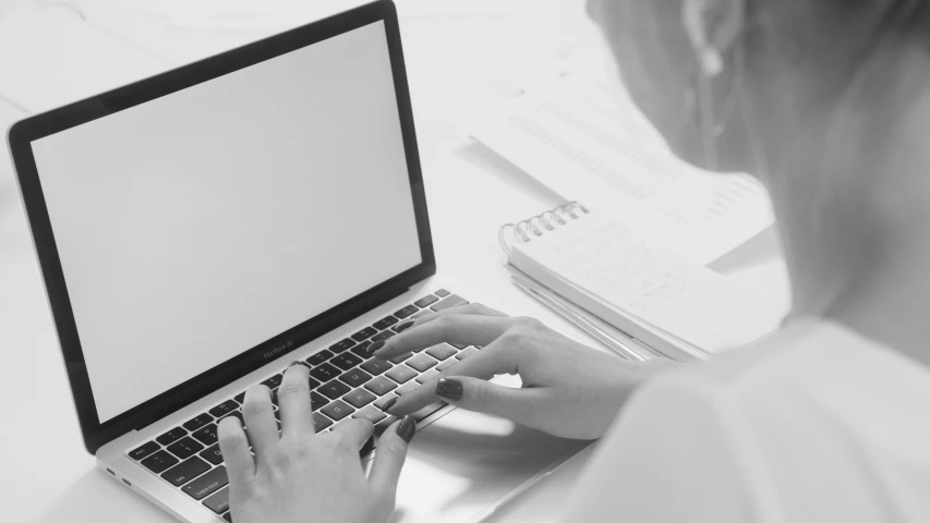 a woman sitting at a desk using a laptop computer, a black and white photo, pexels, computer art, background image, teaser, document photo, high resolution