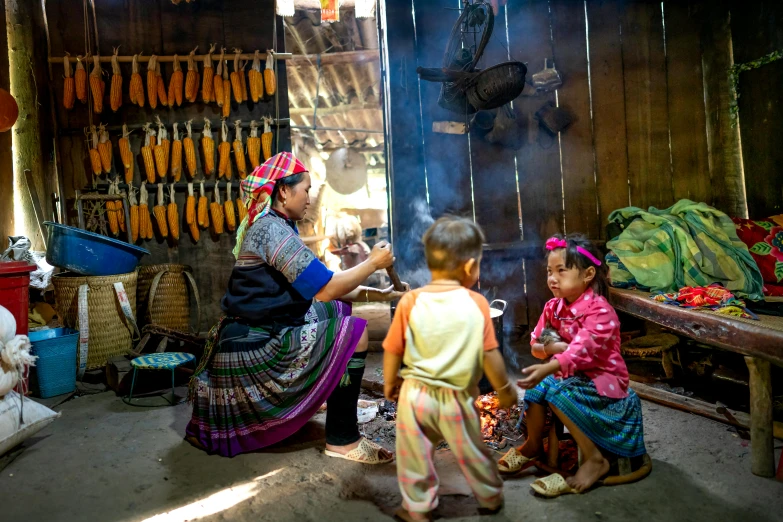 a group of women sitting next to each other in a room, by Daniel Lieske, pexels contest winner, with some sausages on the fire, bamboo huts, kids playing, avatar image