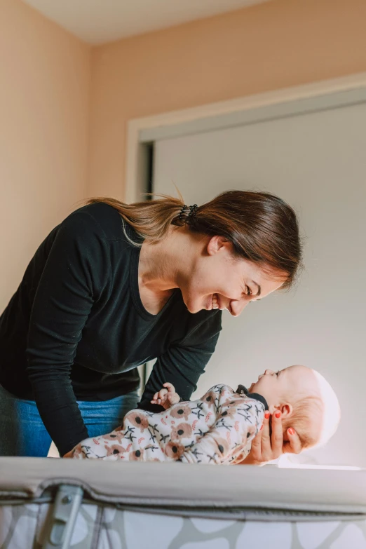 a woman standing over a baby in a crib, happening, manuka, profile image, stretch, clinical