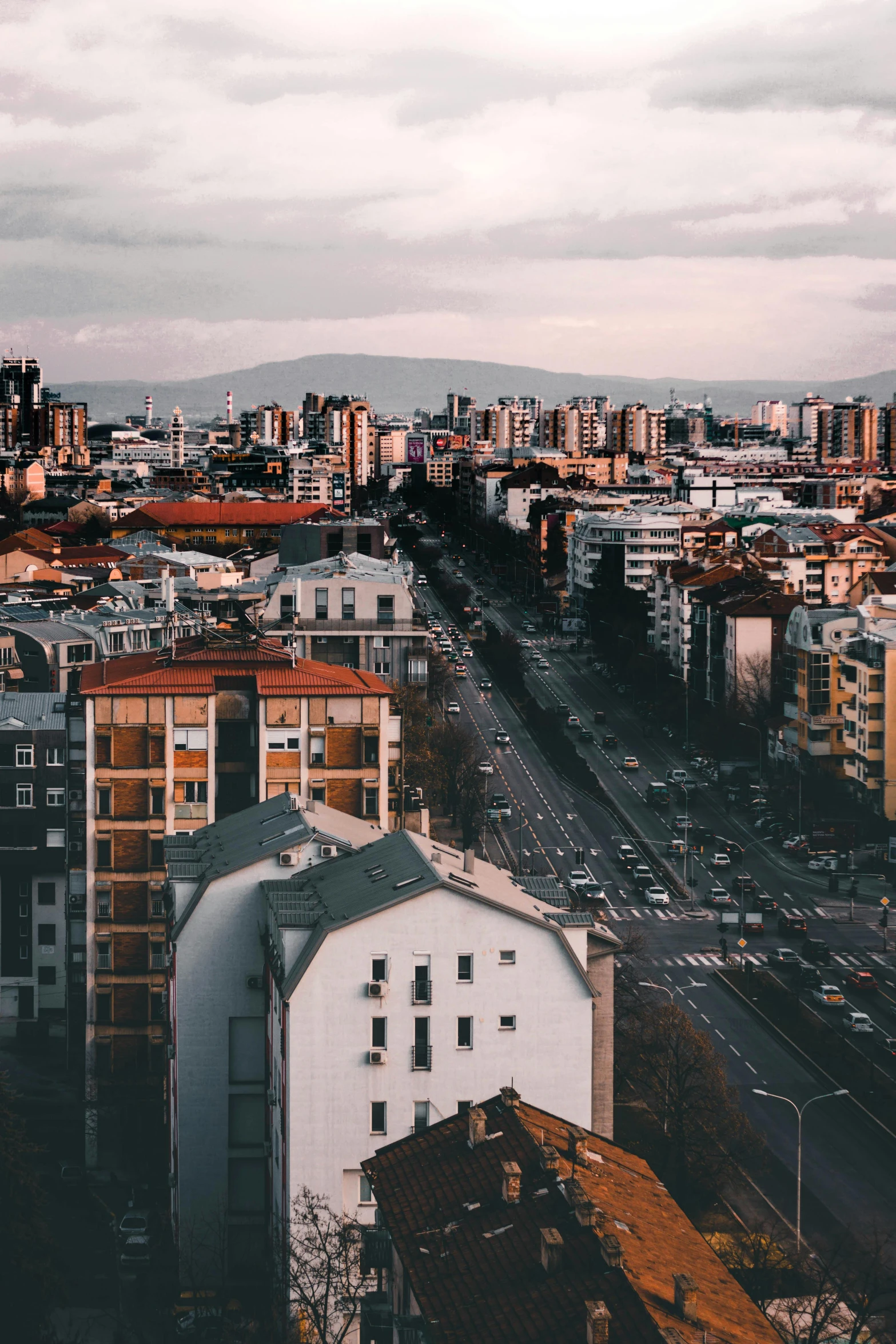 a view of a city from the top of a building, by Matija Jama, hills in the background, jovana rikalo, full building, wide