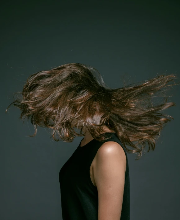 a woman with her hair blowing in the wind, an album cover, by Attila Meszlenyi, trending on unsplash, studio photo, brown haired, paul barson, your head turns back