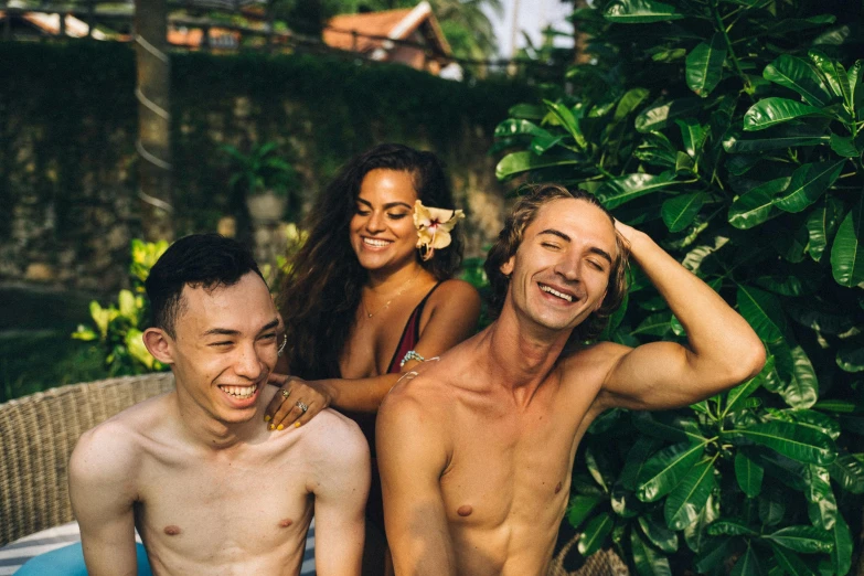 a group of people sitting around a swimming pool, jungle around him, happy vibes, lachlan bailey, shaved temple