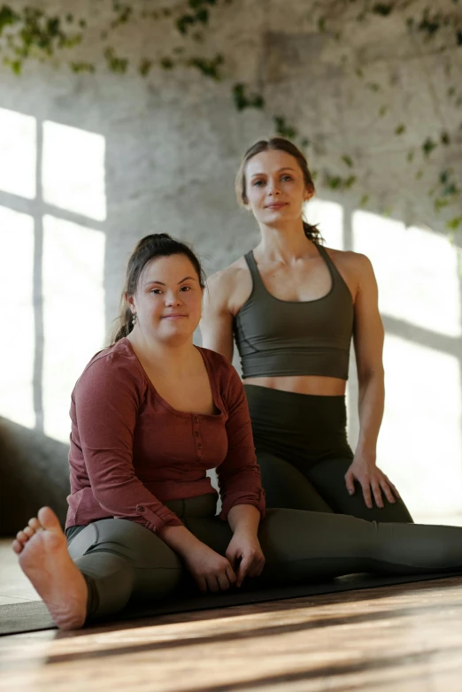 a couple of women sitting on top of a yoga mat, a portrait, pexels contest winner, renaissance, low quality photo, plus-sized, standing athletic pose, brown