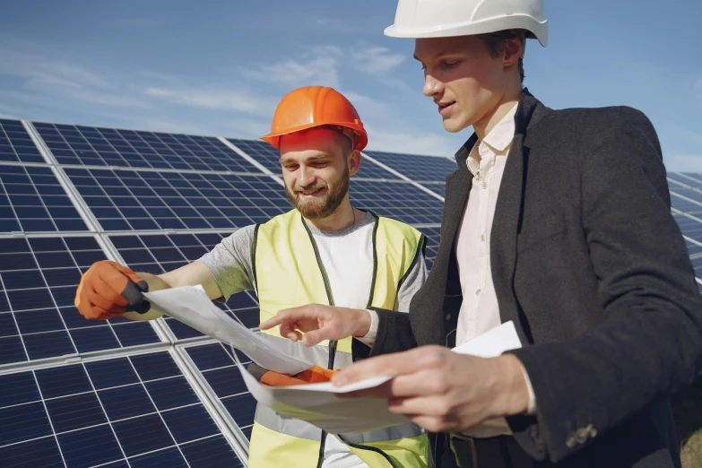 two men standing next to each other in front of solar panels, a photo, shutterstock, renaissance, wearing hi vis clothing, document photo, customers, avatar image