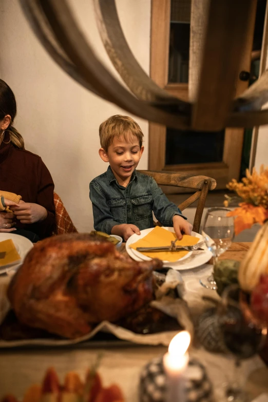 a group of people sitting at a table with a turkey, food