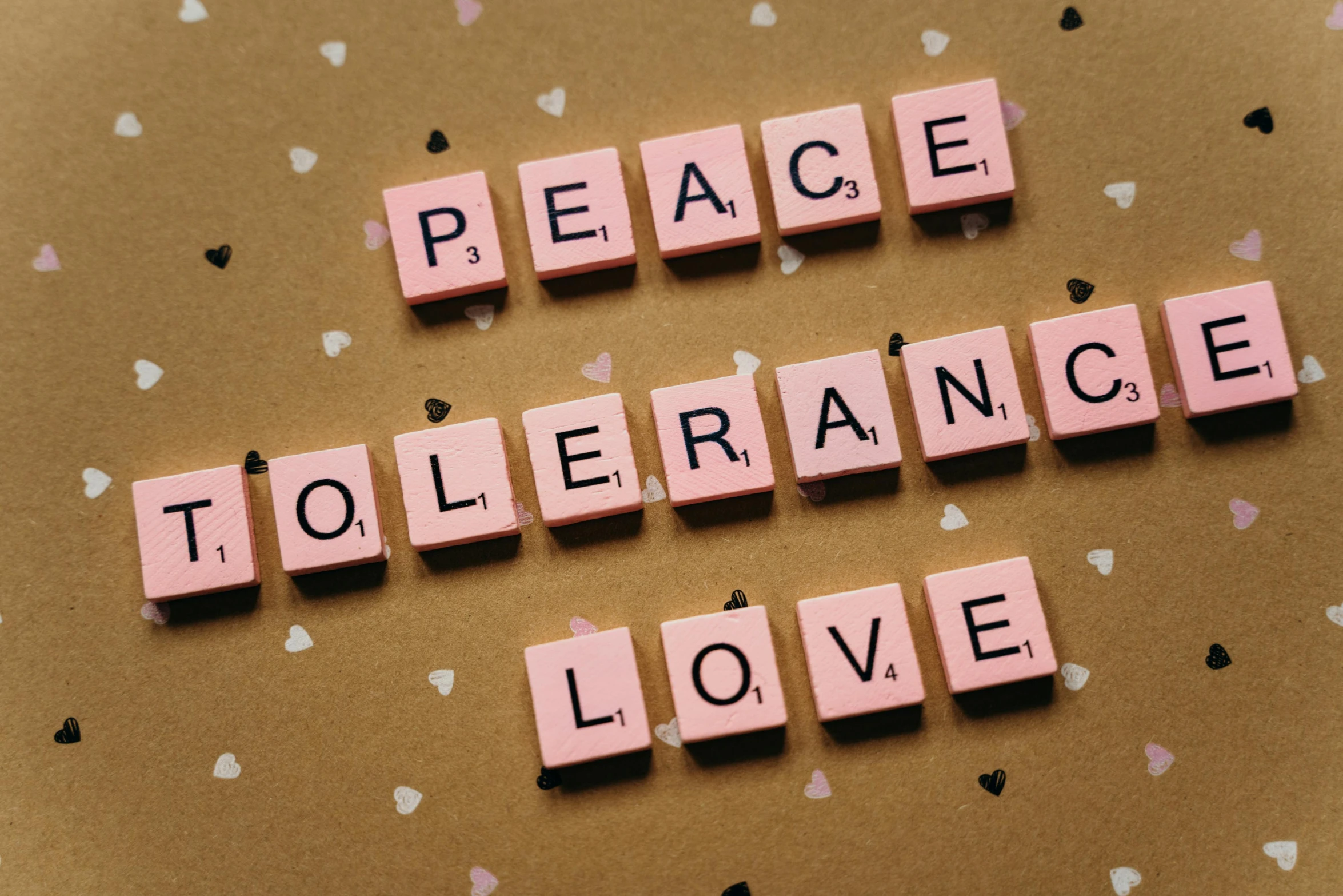pink scrabbles spelling peace, tolerance, and love on a brown background, pixabay, renaissance, vocaloid, instagram post, 🎀 🧟 🍓 🧚, violence