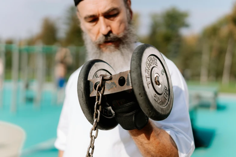 a man with a beard holding a pair of dumb dumb dumb dumb dumb dumb dumb dumb dumb dumb dumb dumb dumb dumb dumb dumb dumb dumb dumb, an album cover, by Alexander Fedosav, pexels contest winner, hurufiyya, lifting weights, orthodox, chains, photo from a spectator
