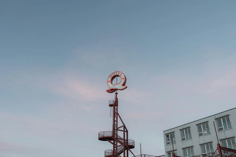 a red fire hydrant sitting next to a tall building, inspired by Victor Enrich, unsplash, berlin secession, rollercoaster, evening sky, enso, low quality photo