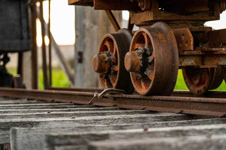 a close up of a train on a track, by Andries Stock, pexels contest winner, renaissance, wooden structures, cart wheels, looking at the ground, profile picture 1024px