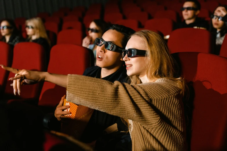 a man and a woman sitting in a movie theater, trending on pexels, interactive art, digital glasses, ocarina of time movie, instagram photo, [ theatrical ]
