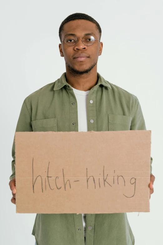 a man holding a sign that says hitch - hiking, by Niko Henrichon, tinder profile, atiba jefferson, productphoto, thick lining