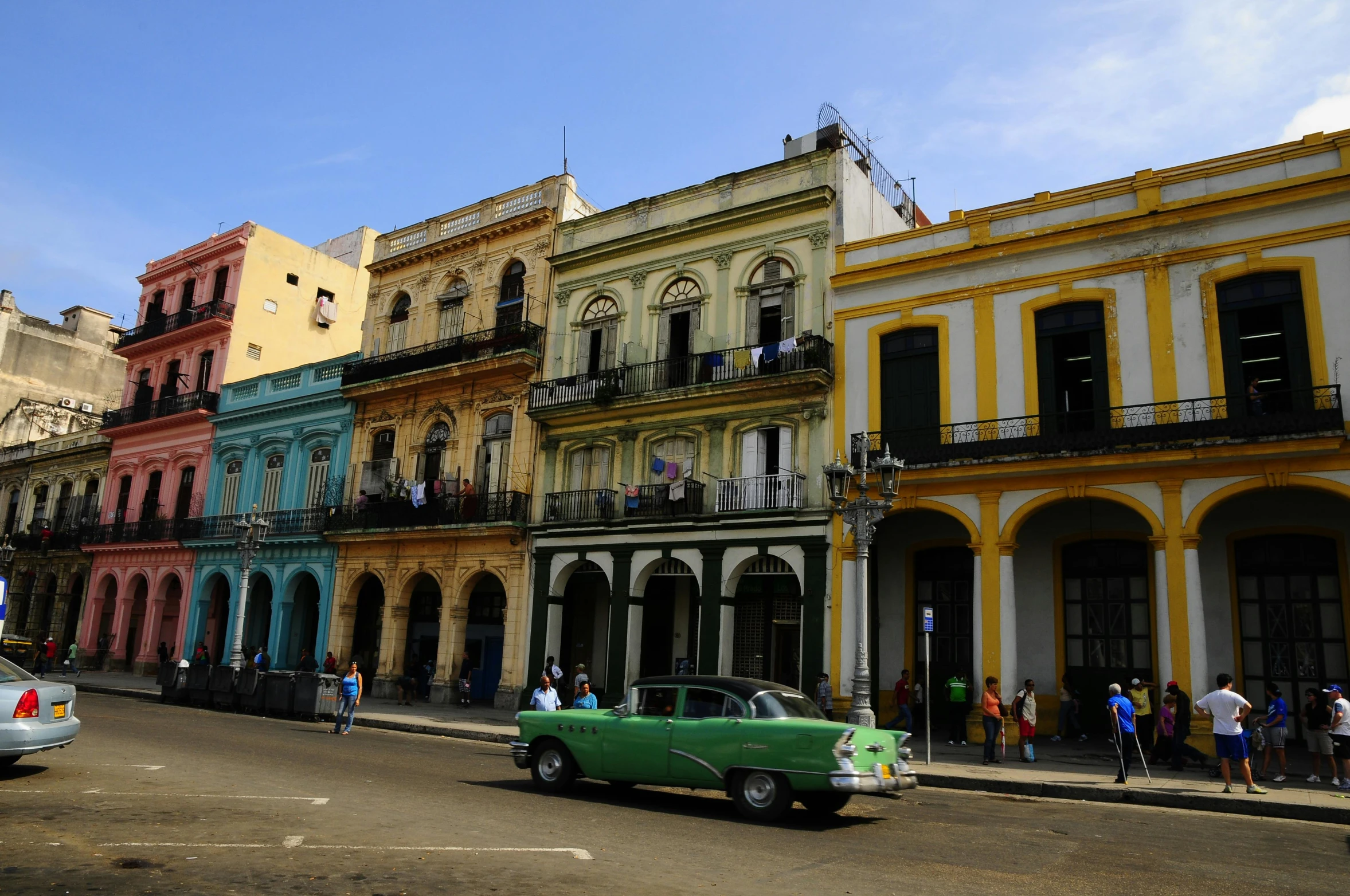 a green car driving down a street next to tall buildings, pexels contest winner, renaissance, cuban women in havana, chartreuse and orange and cyan, square, historical