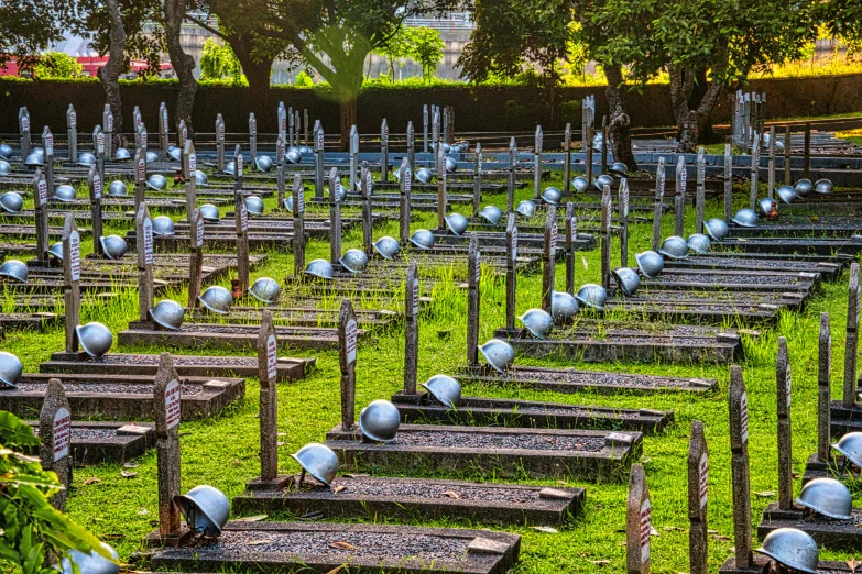 a field filled with lots of metal objects sitting on top of a lush green field, a photo, by Alexander Fedosav, flickr, in a graveyard, sao paulo, coneheads, bright vivid lighting