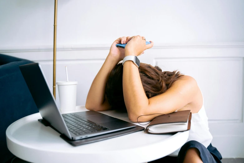 a woman sitting at a table in front of a laptop, by Julia Pishtar, pexels, two exhausted, passed out, natasha tan maciej kuciara, crushed