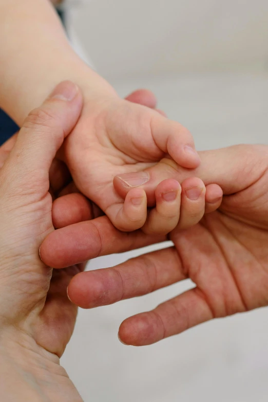 a close up of a person holding a person's hand, different sizes, young child, uploaded, no cropping