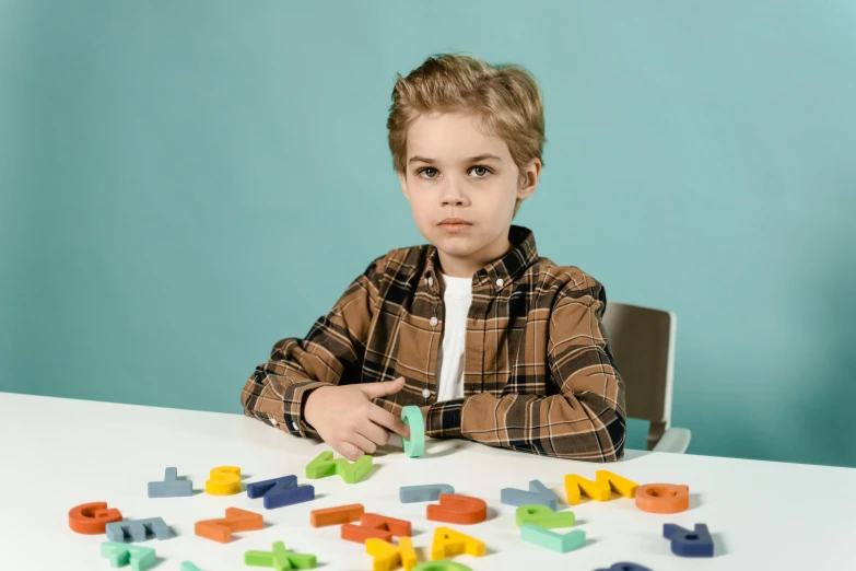 a little boy that is sitting at a table, letters, set pieces, abcdefghijklmnopqrstuvwxyz, thumbnail