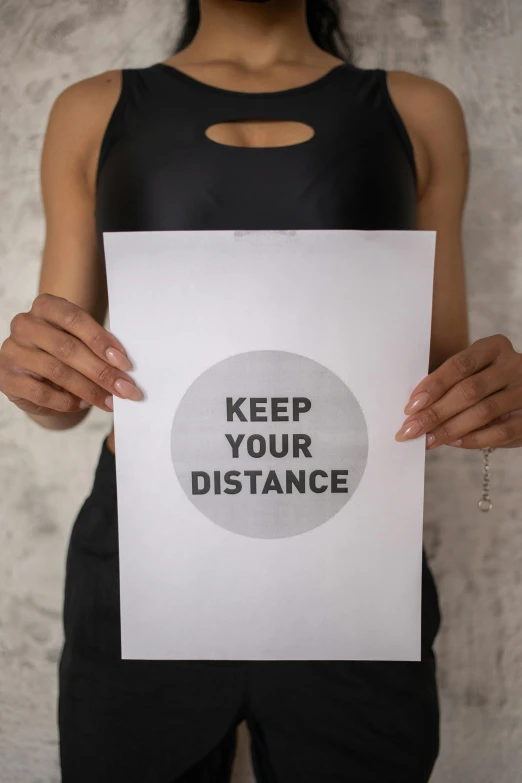 a woman holding a sign that says keep your distance, a poster, by Julia Pishtar, large format picture, workout, digital image, do