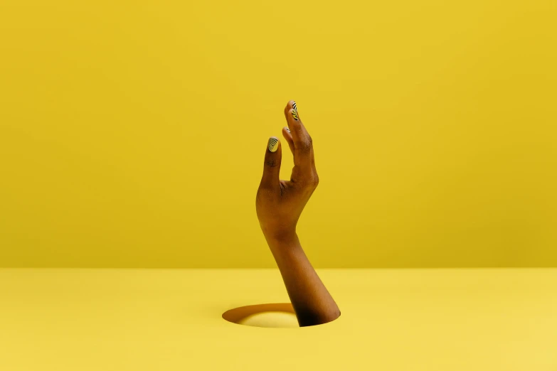 a person's hand reaching out of a hole, an album cover, inspired by Robert Mapplethorpe, trending on pexels, yellow skin, contemporary sculpture, aida muluneh, detailed product image