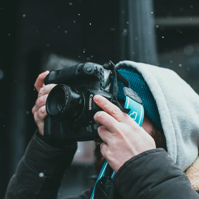 a person taking a picture with a camera, pexels contest winner, wearing teal beanie, covered with tar. dslr, wearing a hood, today\'s featured photograph 4k