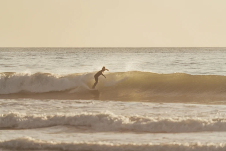 a man riding a wave on top of a surfboard, by Eglon van der Neer, unsplash contest winner, figuration libre, in a sunset haze, mid action, soft-sanded coastlines, taken with canon 5d mk4