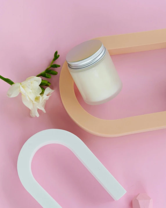 a pair of scissors and a jar of cream on a pink background, by Eden Box, featured on pinterest, curvy build, detail shot, centred, candle