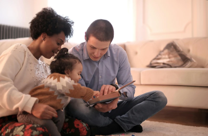 a family sitting on the floor looking at a tablet, by Arabella Rankin, pexels, figuration libre, diverse, caring fatherly wide forehead, profile image, decoration