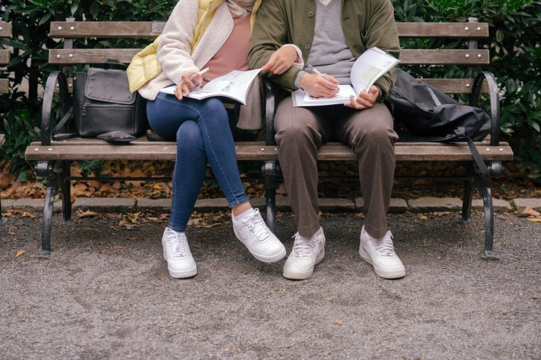 a couple of people that are sitting on a bench, trending on pexels, holding books, scribbled, wearing white sneakers, scientific study